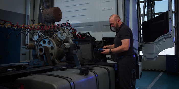 man infront of truck with device 