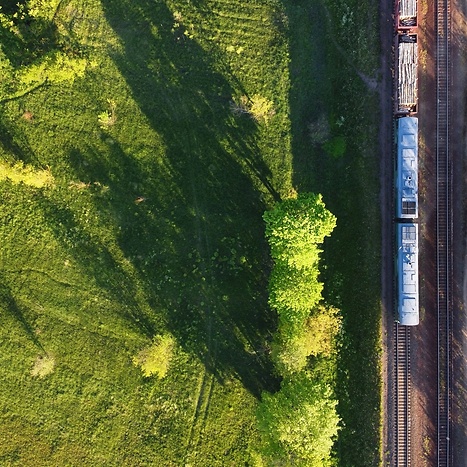 Train driving through a green landscape