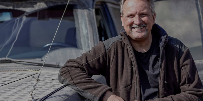 workshop employee leaning on car rear