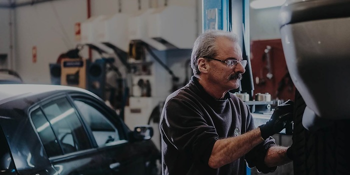 workshop employee working on brakes