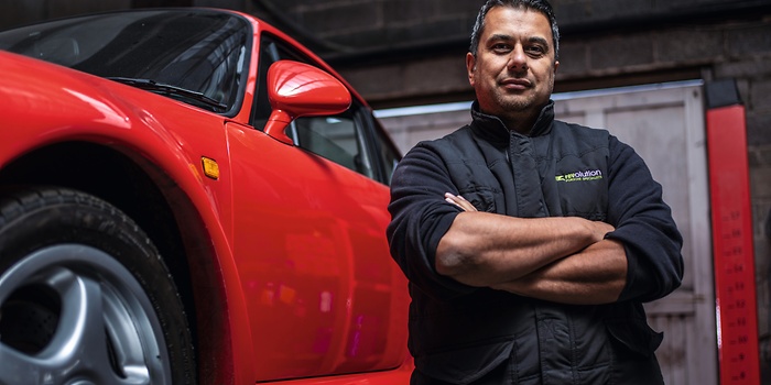mechanic posing in front of car