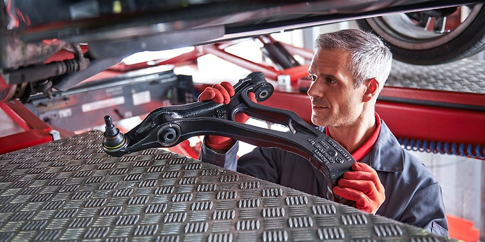 workshop employee handling used car part