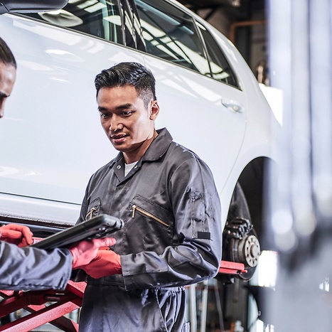 man in workshop infront of a car with brake booster 