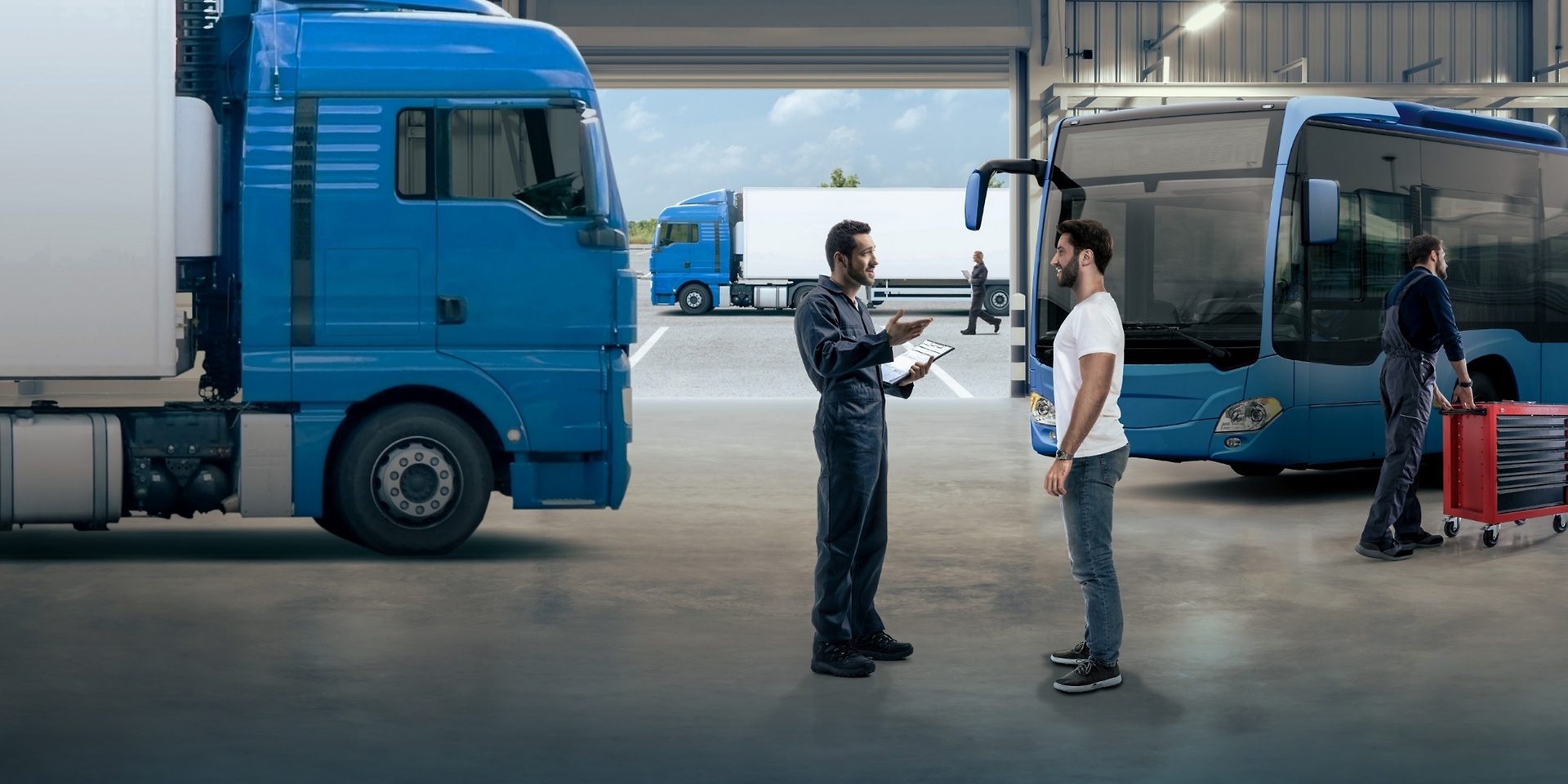 two men in workshop with truck in the background
